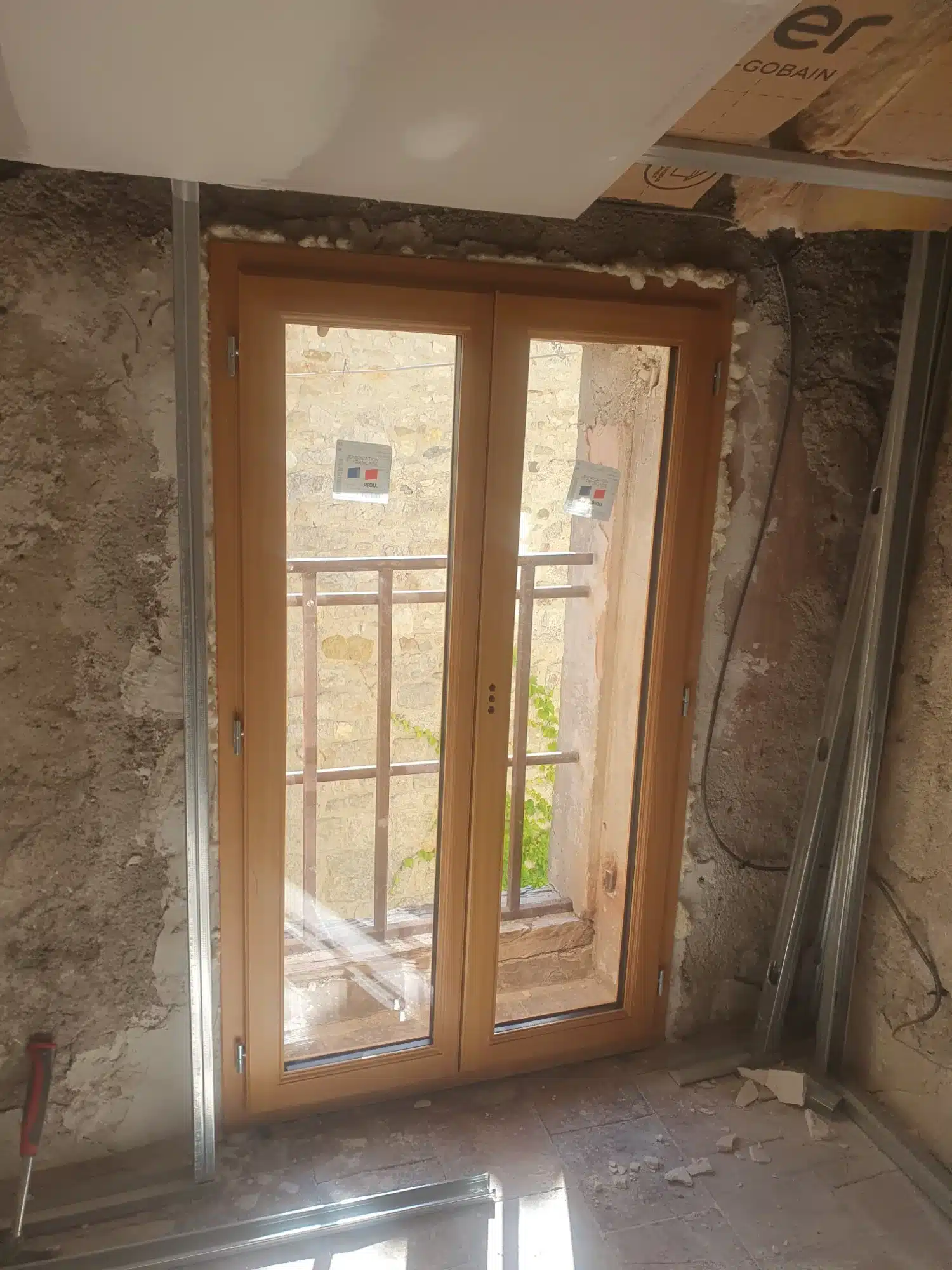 Ébéniste en action : Traçage de précision pour la menuiserie. Gros plan : ébéniste en tablier traçant des marques précises sur du bois brut à l'aide d'un crayon et d'une équerre. Maillet et copeaux sur l'établi.