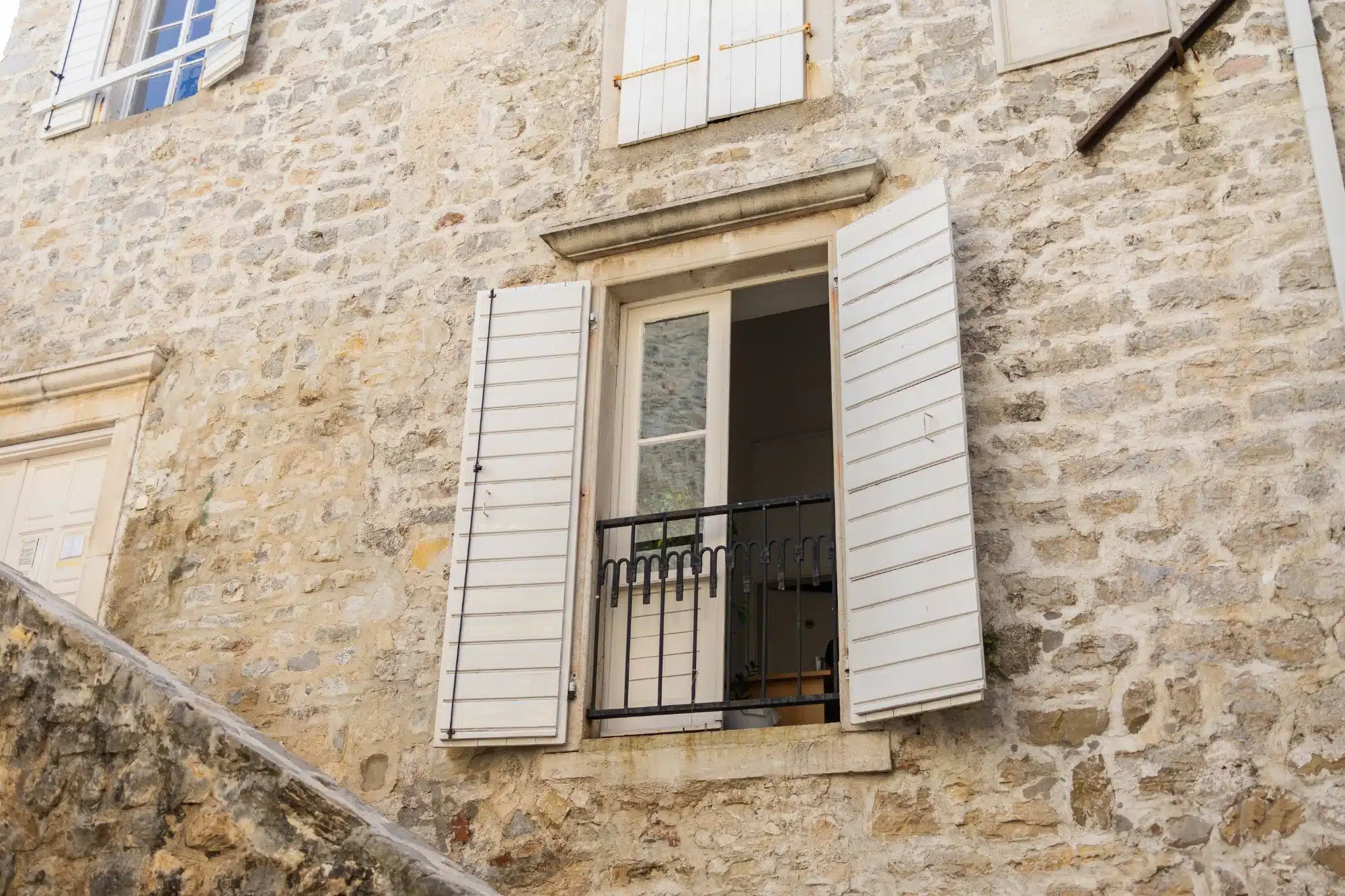 Ébéniste en action : Traçage de précision pour la menuiserie. Gros plan : ébéniste en tablier traçant des marques précises sur du bois brut à l'aide d'un crayon et d'une équerre. Maillet et copeaux sur l'établi.