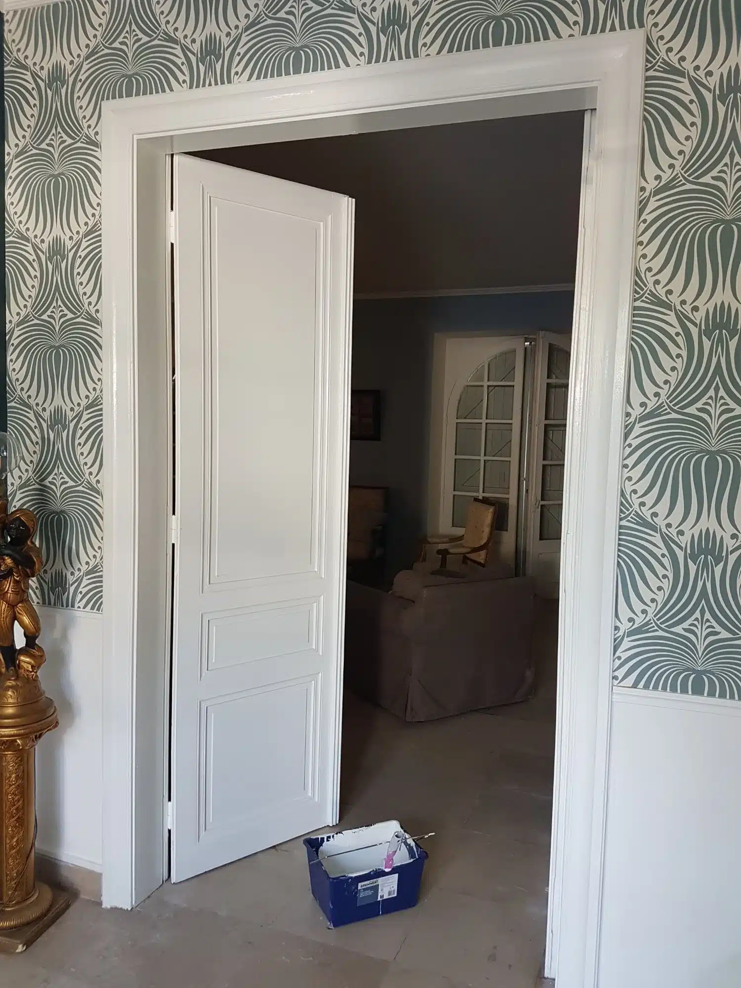 Ébéniste en action : Traçage de précision pour la menuiserie. Gros plan : ébéniste en tablier traçant des marques précises sur du bois brut à l'aide d'un crayon et d'une équerre. Maillet et copeaux sur l'établi.